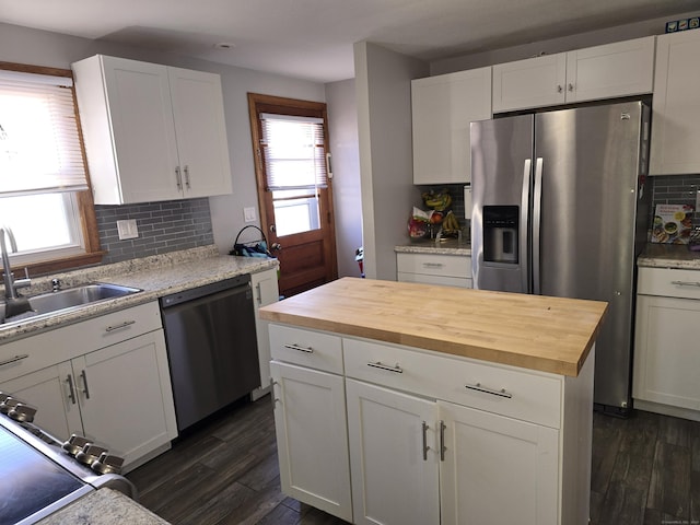 kitchen with decorative backsplash, dark hardwood / wood-style flooring, white cabinetry, and appliances with stainless steel finishes