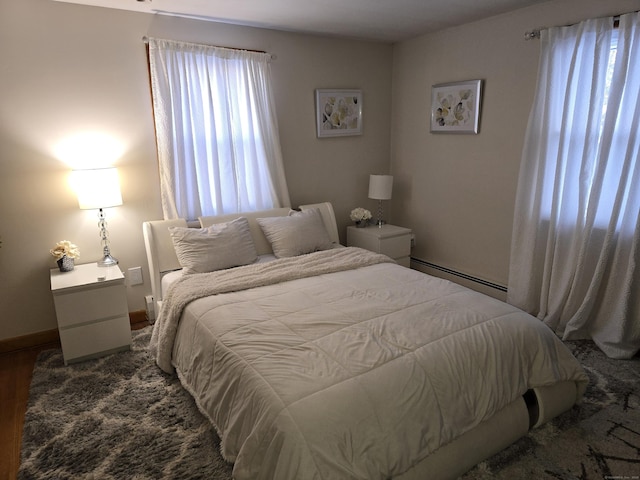 bedroom with a baseboard radiator and wood-type flooring