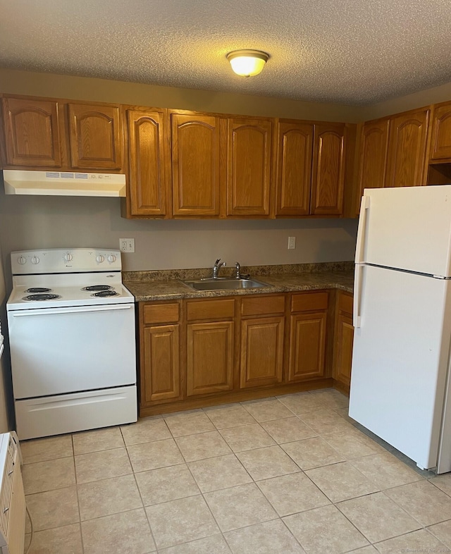 kitchen with a textured ceiling, sink, light tile patterned floors, and white appliances