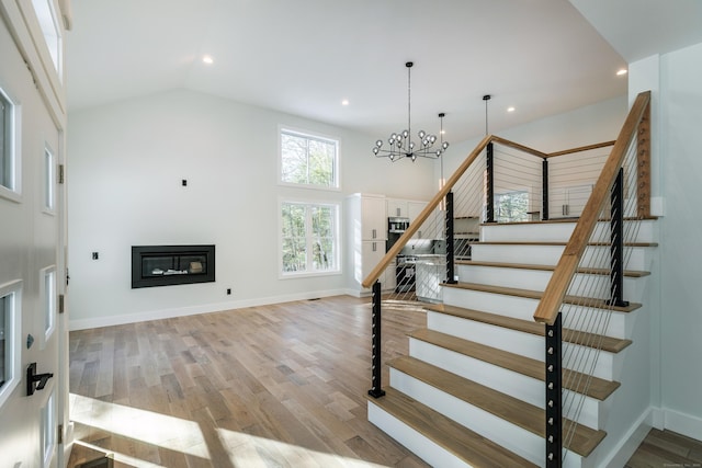 68 Paxton Ct, Goshen, CT 06756 - stairway featuring a chandelier, wood finished floors, recessed lighting, a glass covered fireplace, and baseboards