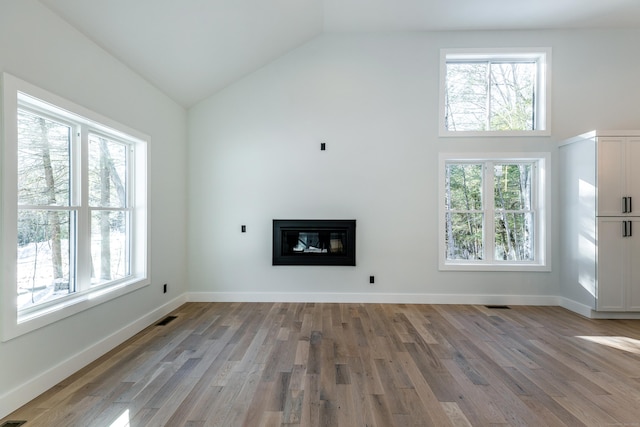 unfurnished living room featuring a healthy amount of sunlight and wood finished floors