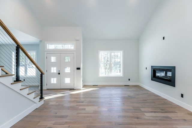 entrance foyer with stairs, wood finished floors, and baseboards