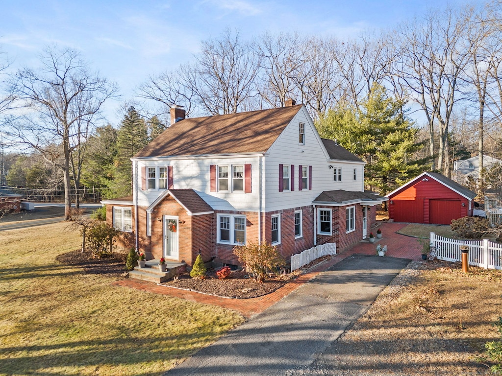 view of front of property featuring an outbuilding, a front lawn, and a garage