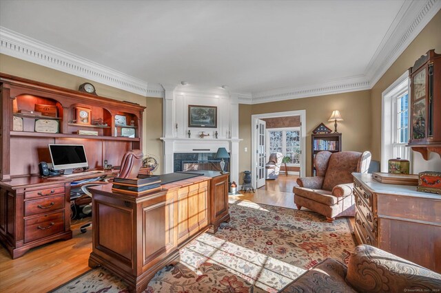 office featuring a healthy amount of sunlight, light wood-type flooring, and ornamental molding