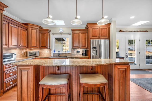 23 Olmstead Rd, East Haddam, CT 06423 - kitchen with stainless steel fridge with ice dispenser, a skylight, crown molding, a sink, and backsplash