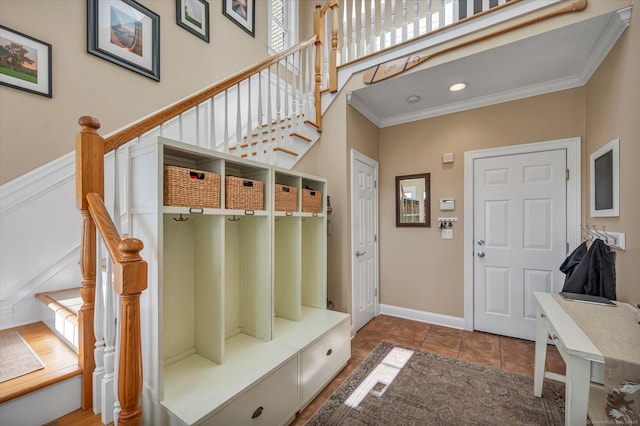 mudroom with tile patterned flooring and ornamental molding