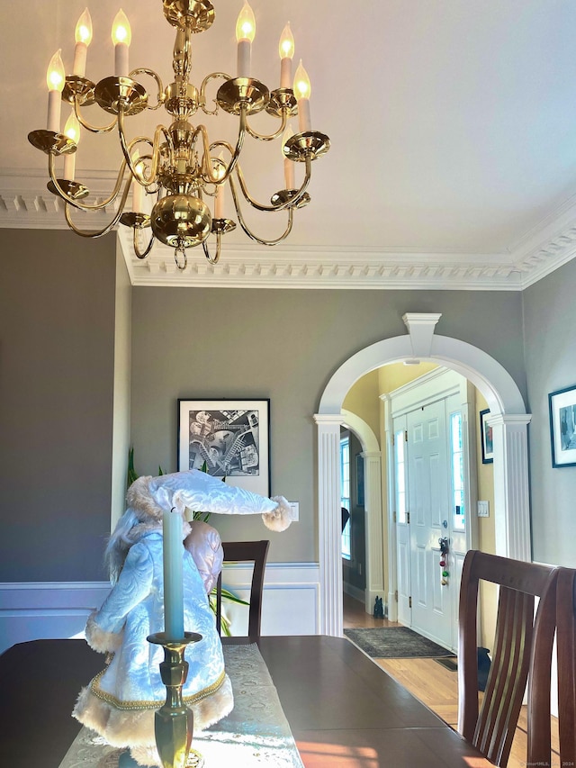 dining area featuring crown molding, hardwood / wood-style floors, and an inviting chandelier