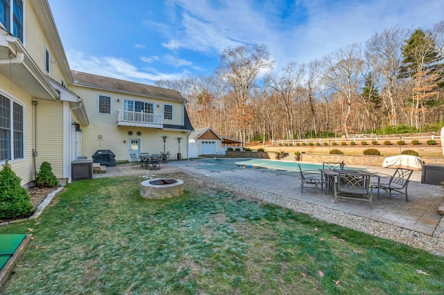 view of yard with a fire pit, a patio, and a covered pool