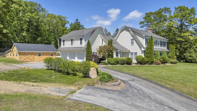 23 Olmstead Rd, East Haddam, CT 06423 - view of front facade featuring a garage, asphalt driveway, a front lawn, a gambrel roof, and a chimney