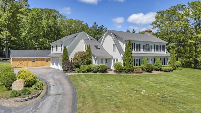 23 Olmstead Rd, East Haddam, CT 06423 - view of front of home with a gambrel roof, asphalt driveway, a chimney, an attached garage, and a front yard