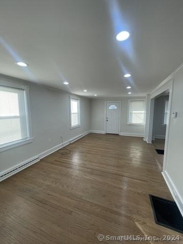 interior space with dark hardwood / wood-style flooring and a baseboard heating unit