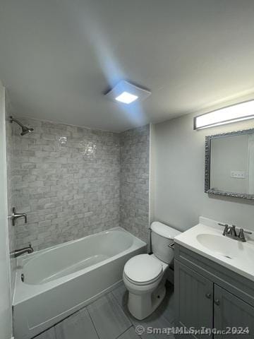 full bathroom featuring tile patterned floors, vanity, tiled shower / bath combo, and toilet