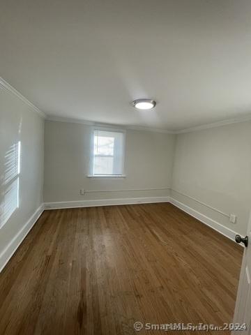 unfurnished room with dark hardwood / wood-style floors and ornamental molding