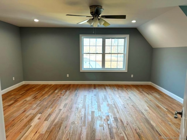 additional living space with ceiling fan, lofted ceiling, and light wood-type flooring