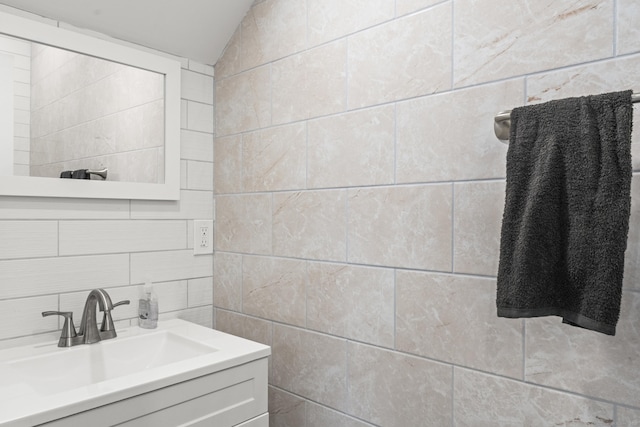 23 Moore Ave, New London, CT 06320 - bathroom featuring tile walls, vanity, lofted ceiling, and tasteful backsplash