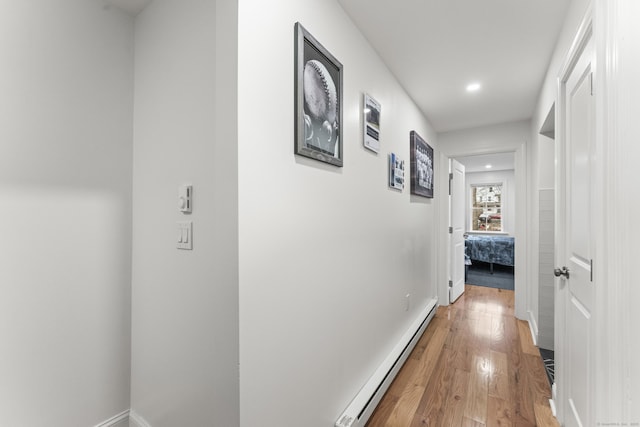 hall with baseboard heating and hardwood / wood-style floors