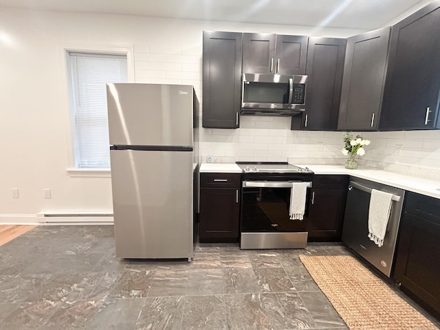 kitchen featuring baseboard heating, appliances with stainless steel finishes, and decorative backsplash