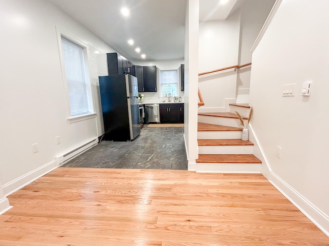 interior space with sink, a baseboard heating unit, and stainless steel appliances