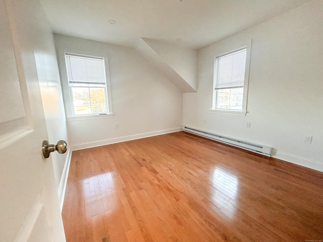 additional living space featuring light hardwood / wood-style floors and a baseboard radiator