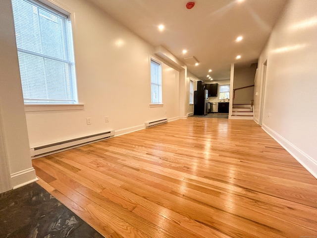 23 Moore Ave, New London, CT 06320 - unfurnished living room with a baseboard radiator, light wood-style floors, recessed lighting, baseboards, and stairway