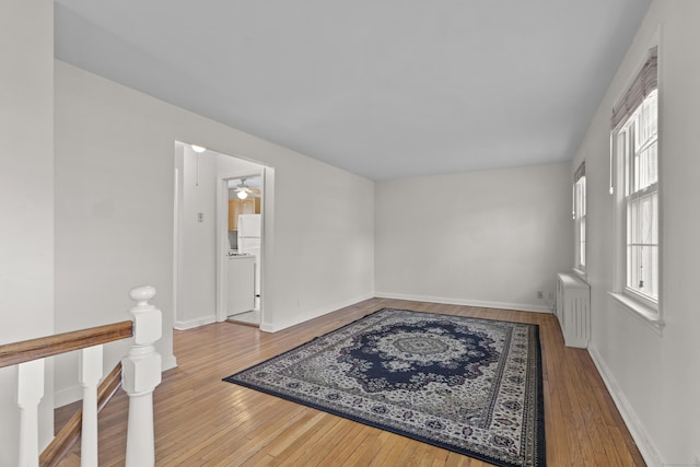 spare room with radiator, ceiling fan, and hardwood / wood-style flooring