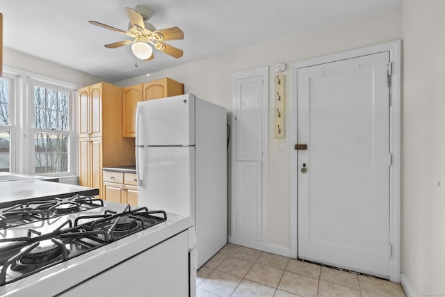 kitchen with ceiling fan, stove, white fridge, light brown cabinetry, and light tile patterned flooring