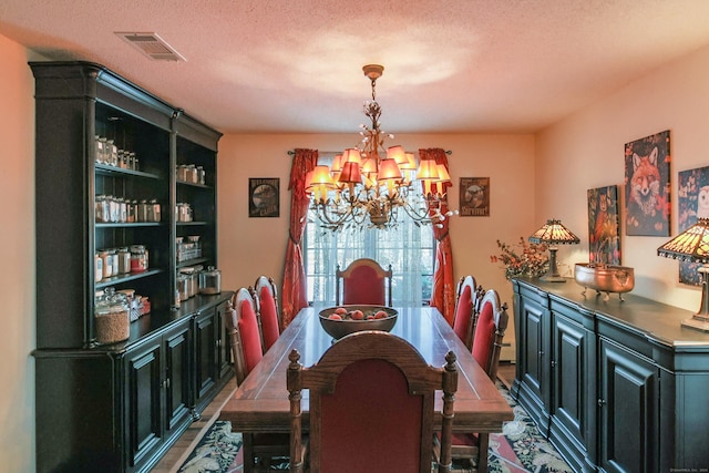 dining space with a chandelier and a textured ceiling