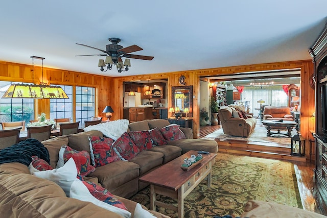 living room featuring ceiling fan, wood-type flooring, and wooden walls