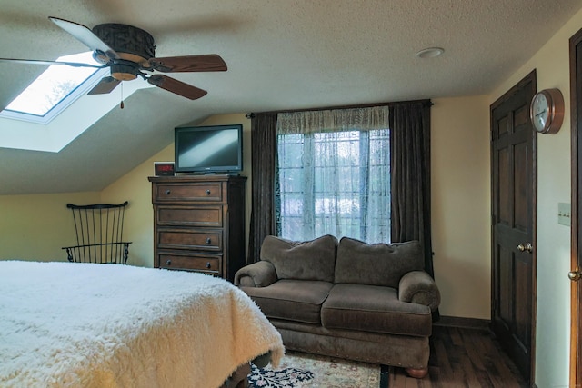 bedroom featuring a textured ceiling, ceiling fan, lofted ceiling with skylight, and dark hardwood / wood-style floors