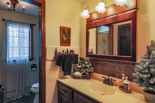 bathroom featuring decorative backsplash, vanity, and toilet