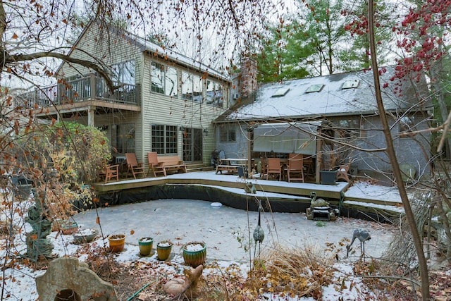 snow covered house featuring a balcony