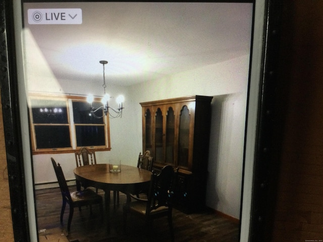 dining space featuring hardwood / wood-style floors and a notable chandelier