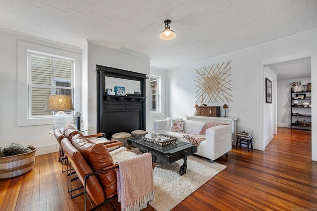 living room with dark hardwood / wood-style flooring and ornamental molding