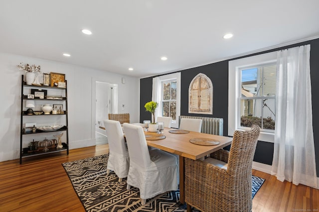 dining space featuring baseboards, wood finished floors, ornamental molding, and recessed lighting