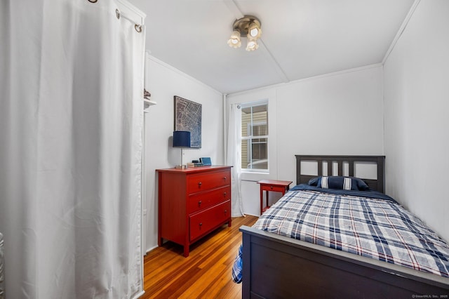 bedroom featuring crown molding and wood finished floors
