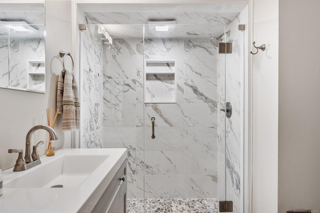 bathroom featuring vanity and a marble finish shower