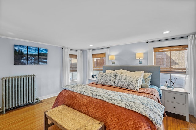 bedroom featuring light wood-style floors, crown molding, and radiator