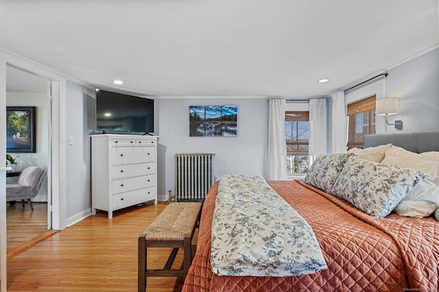 bedroom featuring crown molding, baseboards, recessed lighting, light wood-style floors, and radiator