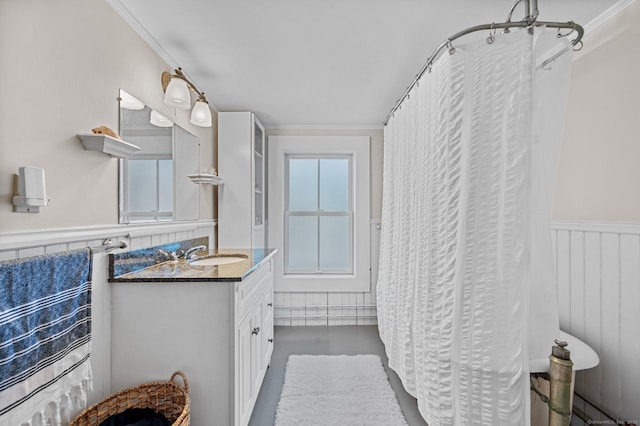 bathroom with vanity, a wainscoted wall, wood finished floors, and crown molding