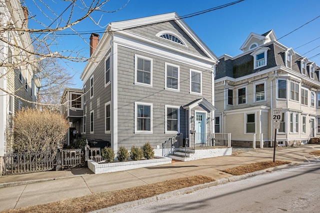 view of front of home featuring a chimney and fence