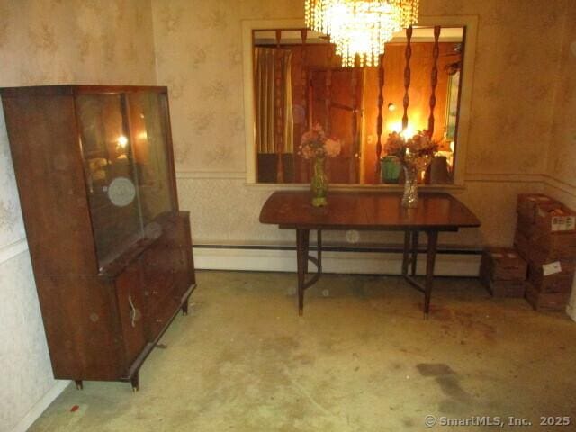 dining space featuring a baseboard heating unit and a chandelier