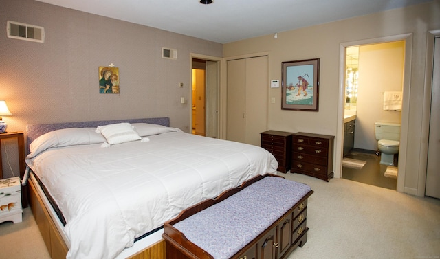 carpeted bedroom featuring ensuite bathroom and a closet