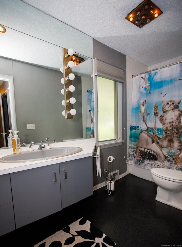 bathroom with curtained shower, vanity, a textured ceiling, and toilet