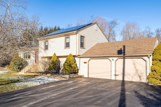 view of front of property with solar panels and a garage