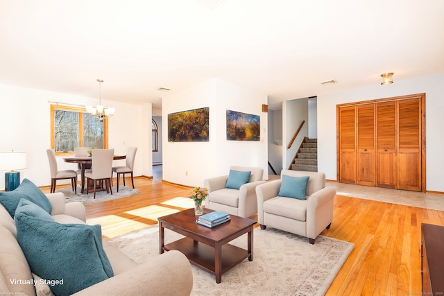 living room with a chandelier and light wood-type flooring