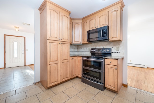 kitchen featuring light brown cabinets, stone counters, baseboard heating, appliances with stainless steel finishes, and tasteful backsplash