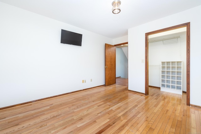 unfurnished bedroom featuring light hardwood / wood-style flooring and a closet