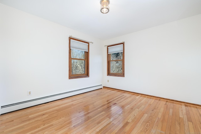 unfurnished room with light hardwood / wood-style flooring and a baseboard heating unit