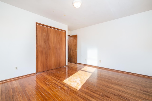 unfurnished bedroom with light hardwood / wood-style flooring and a closet