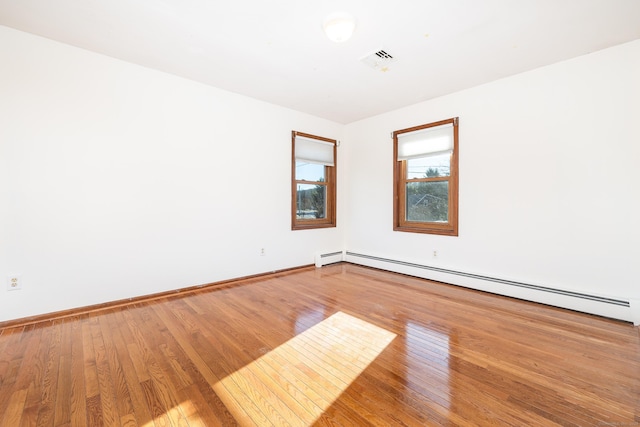 spare room featuring hardwood / wood-style floors and a baseboard radiator